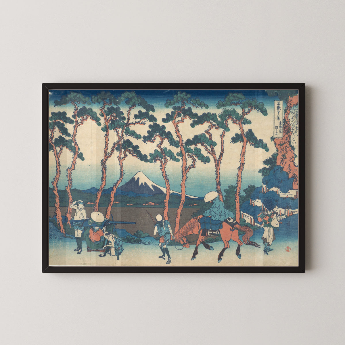 Framed art print of Thirty-six Views of Mount Fuji: Hodogaya on the Tōkaidō by Katsushika Hokusai, in a black frame on a pale wall