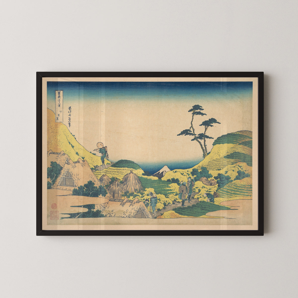 Framed art print of Thirty-six Views of Mount Fuji: Lower Meguro by Katsushika Hokusai, in a black frame on a pale wall