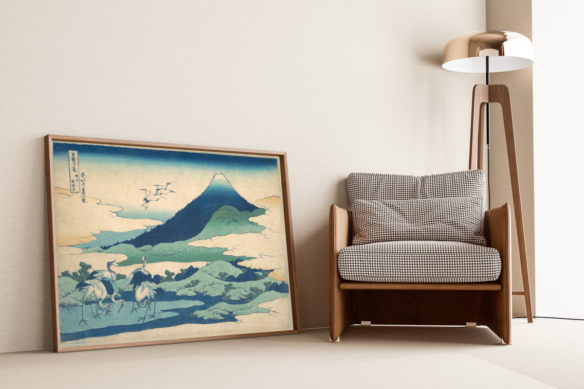 Framed art print of Thirty-six Views of Mount Fuji: Umezawa Manor in Sagami… by Katsushika Hokusai, leaning against a wall beside an armchair and a floor lamp