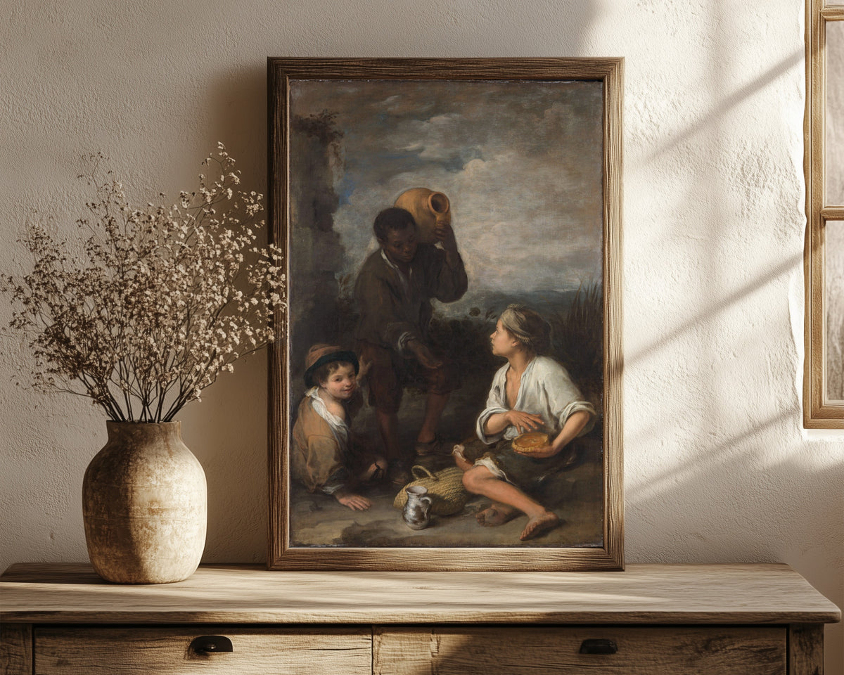 Framed art print of Three Boys by Bartolomé Esteban Murillo, in a dark wood frame leaning on a rustic console beside dried flowers