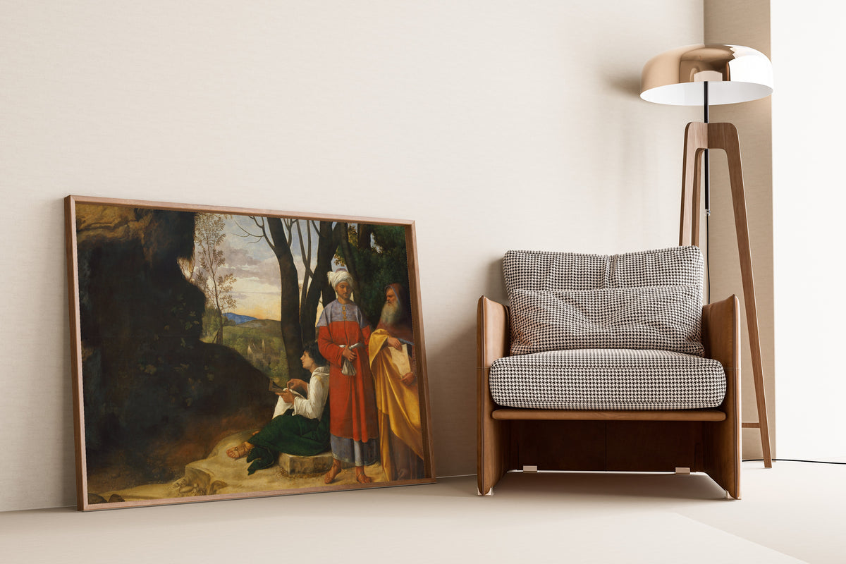 Framed art print of Three Philosophers by Giorgione, leaning against a wall beside an armchair and a floor lamp