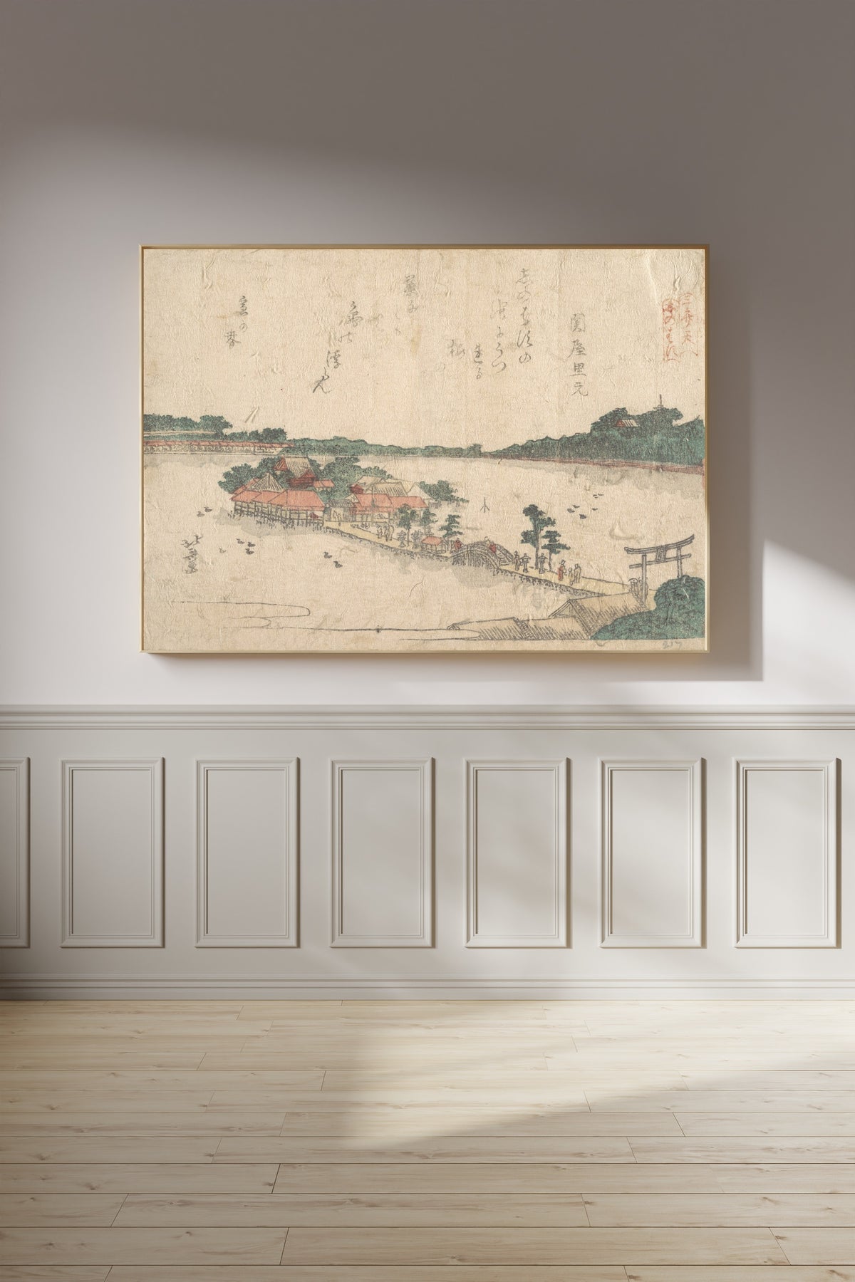 Framed art print of Three Shrines of the Goddess Benten: Shinobazu Pond in Ueno by Katsushika Hokusai, on a panelled wall in afternoon light