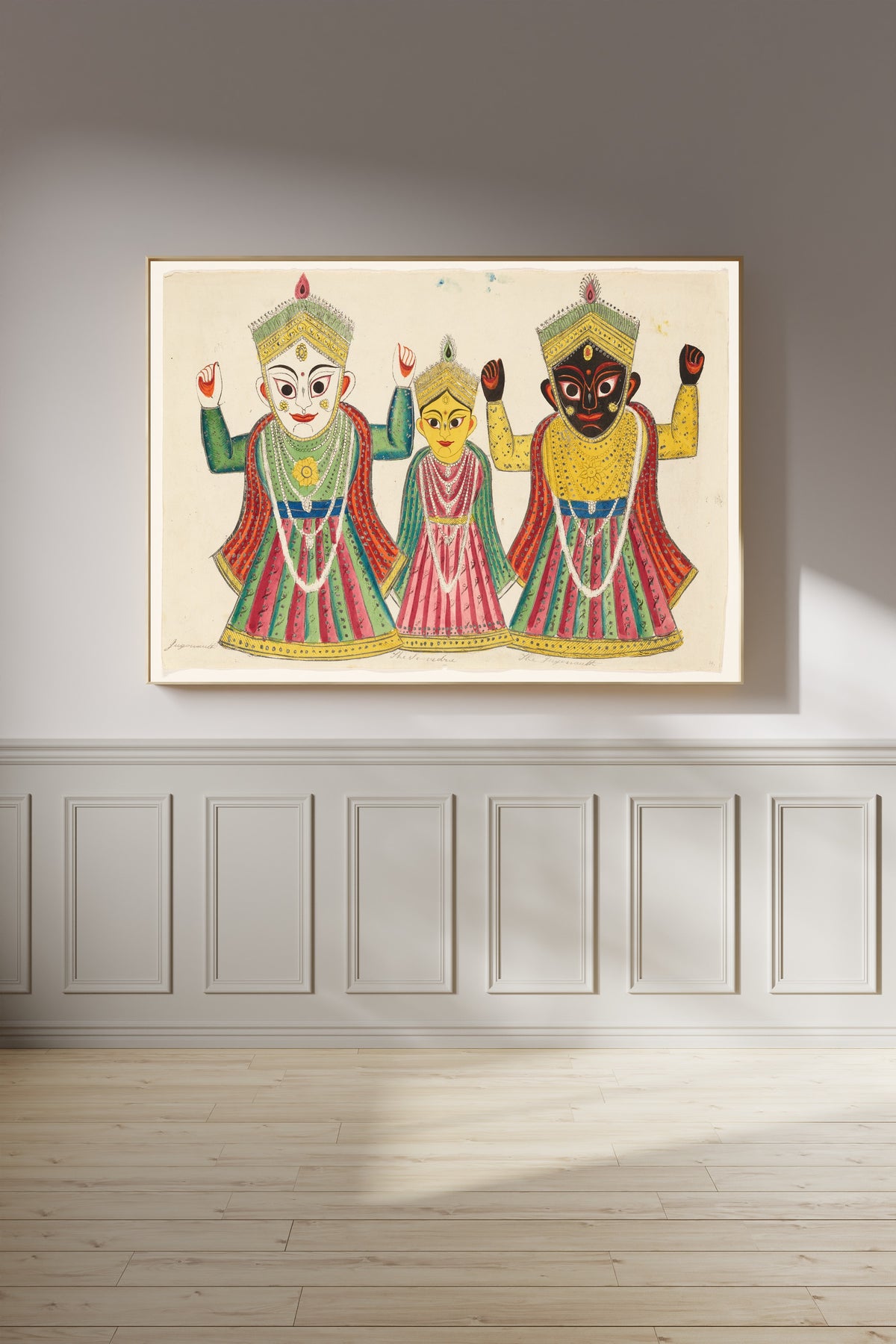Framed art print of Three Temple Banners by Kalighat painter, on a panelled wall in afternoon light