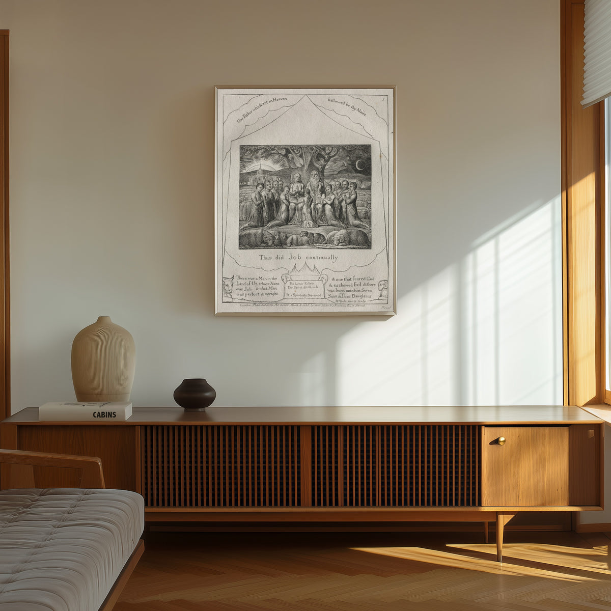 Framed art print of Thus Did Job Continually (Book of Job, Plate 1) by William Blake, in a thin light frame on a sunlit wall above a wooden sideboard