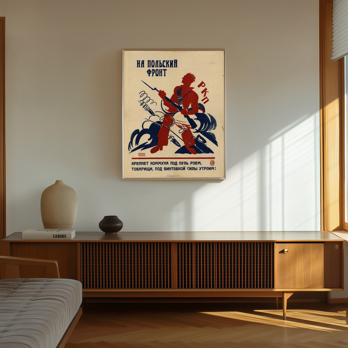 Framed art print of To the Polish front: the Commune grows strong under a… by Ivan Malyutin, in a thin light frame on a sunlit wall above a wooden sideboard