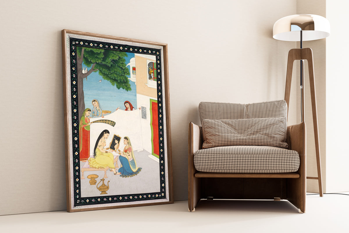 Framed art print of Toilette of Radha by Pahari school, leaning against a wall beside an armchair and a floor lamp