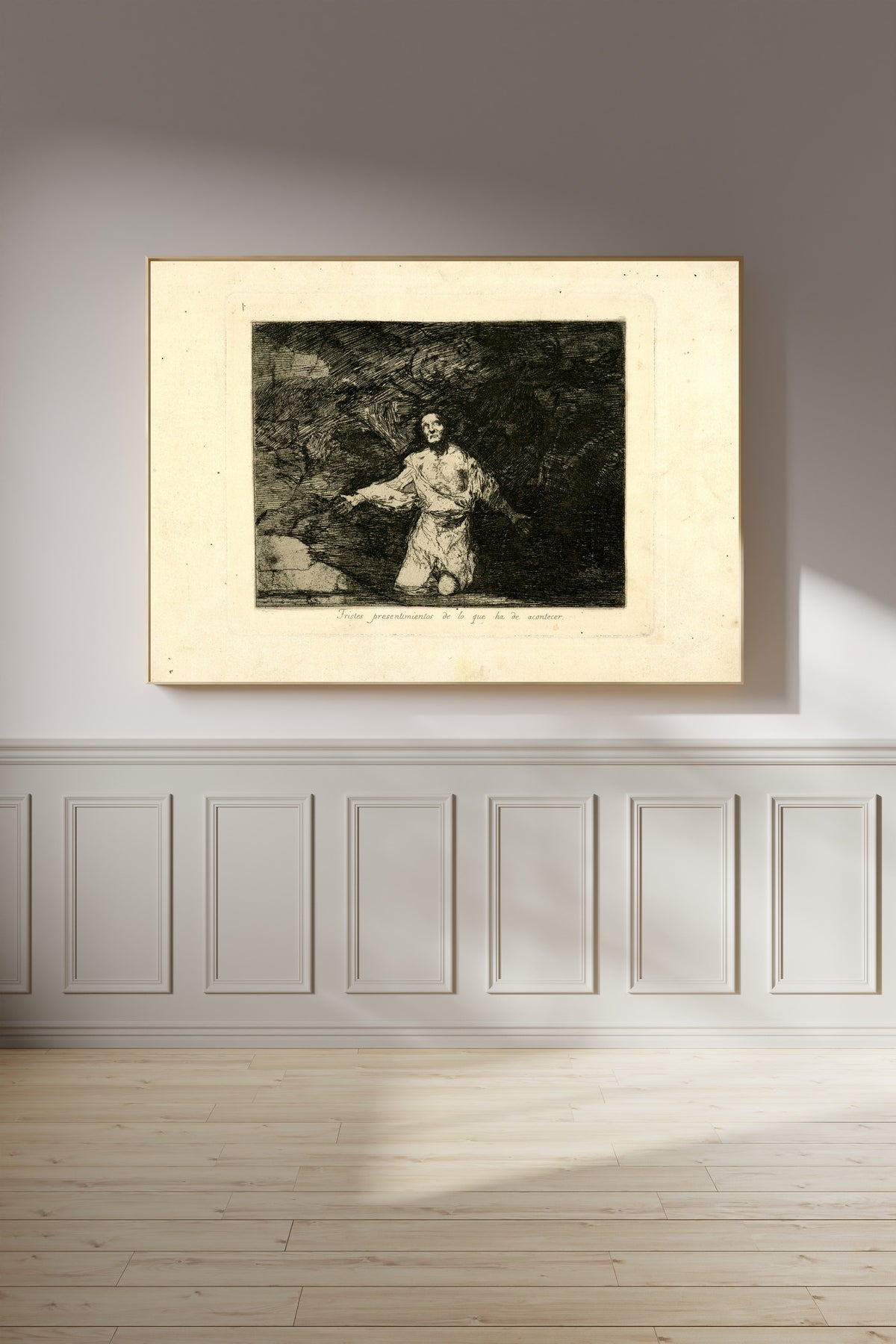 Framed art print of Tristes presentimientos de lo que ha de acontecer (Sad Forebodings of What Is… by Francisco de Goya, on a panelled wall in afternoon light