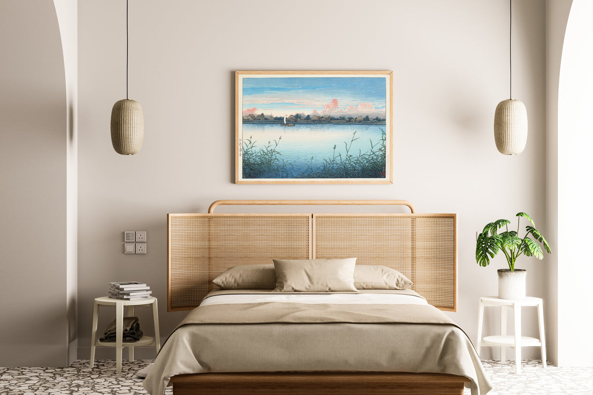 Framed art print of Urayasu in Early Autumn by Kawase Hasui, above a cane-headboard bed