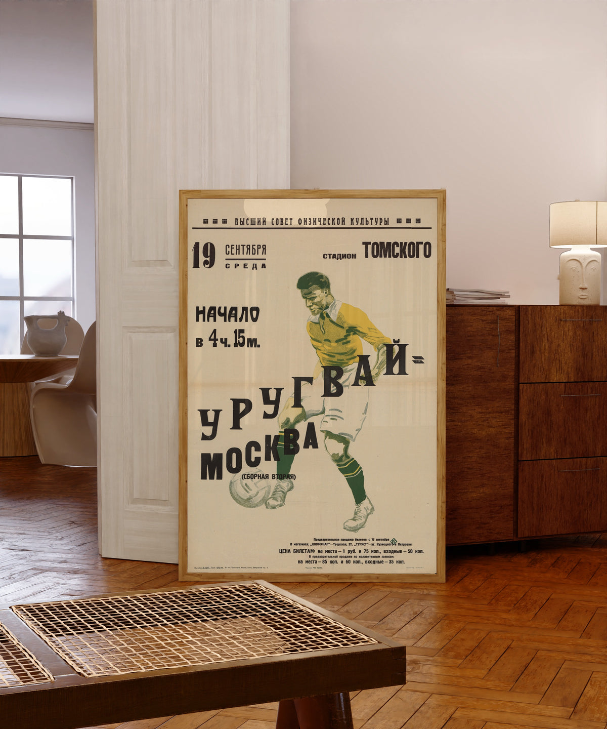 Framed art print of Moscow (second team), in a light wood frame leaning in a warm room with a parquet floor