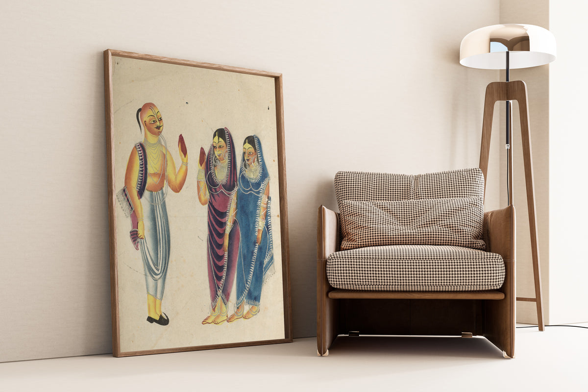 Framed art print of Vaishnava Devotee with Two Women by Kalighat painter, leaning against a wall beside an armchair and a floor lamp