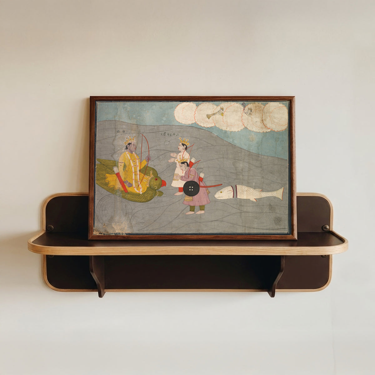 Framed art print of Vanasura's Sons Submit to Krishna by Garhwal school, in a dark wood frame resting on a wall shelf