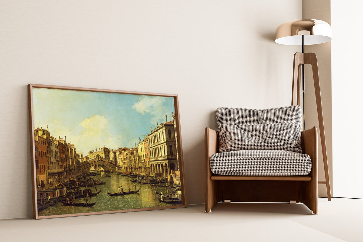 Framed art print of Venice, the Grand Canal from the Palazzo Dolfin-Manin to the… by Canaletto, leaning against a wall beside an armchair and a floor lamp