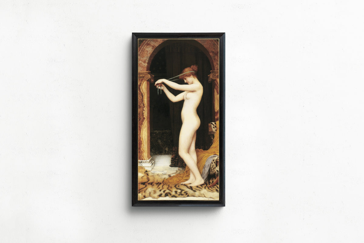 Framed art print of Venus Binding Her Hair by John William Godward, in a slim black frame on a plain white wall