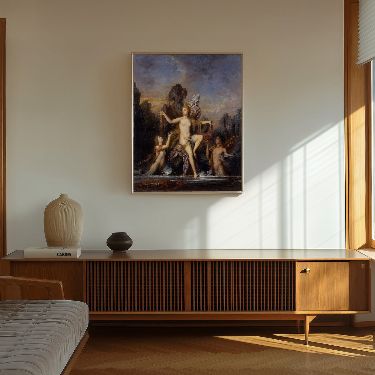 Framed art print of Venus Rising from the Sea by Gustave Moreau, in a thin light frame on a sunlit wall above a wooden sideboard