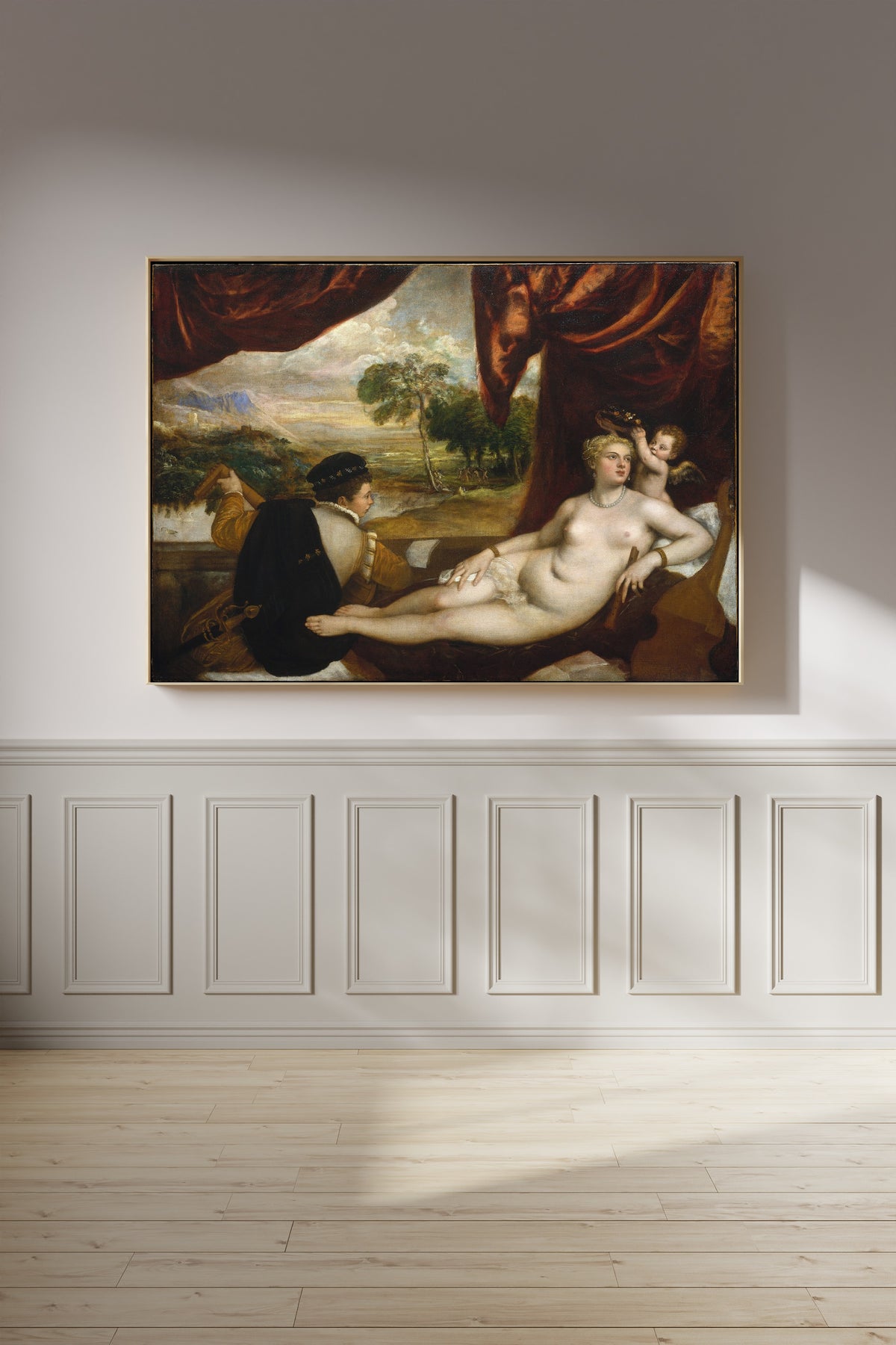 Framed art print of Venus and the Lute Player by Titian, on a panelled wall in afternoon light