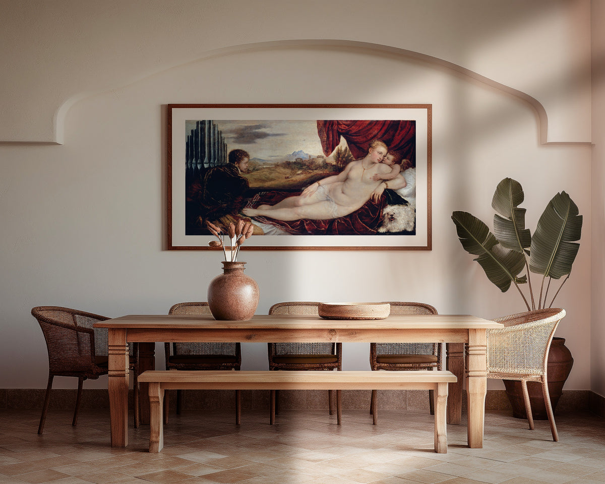 Framed art print of Venus with the Organ Player by Titian, above a wooden dining table