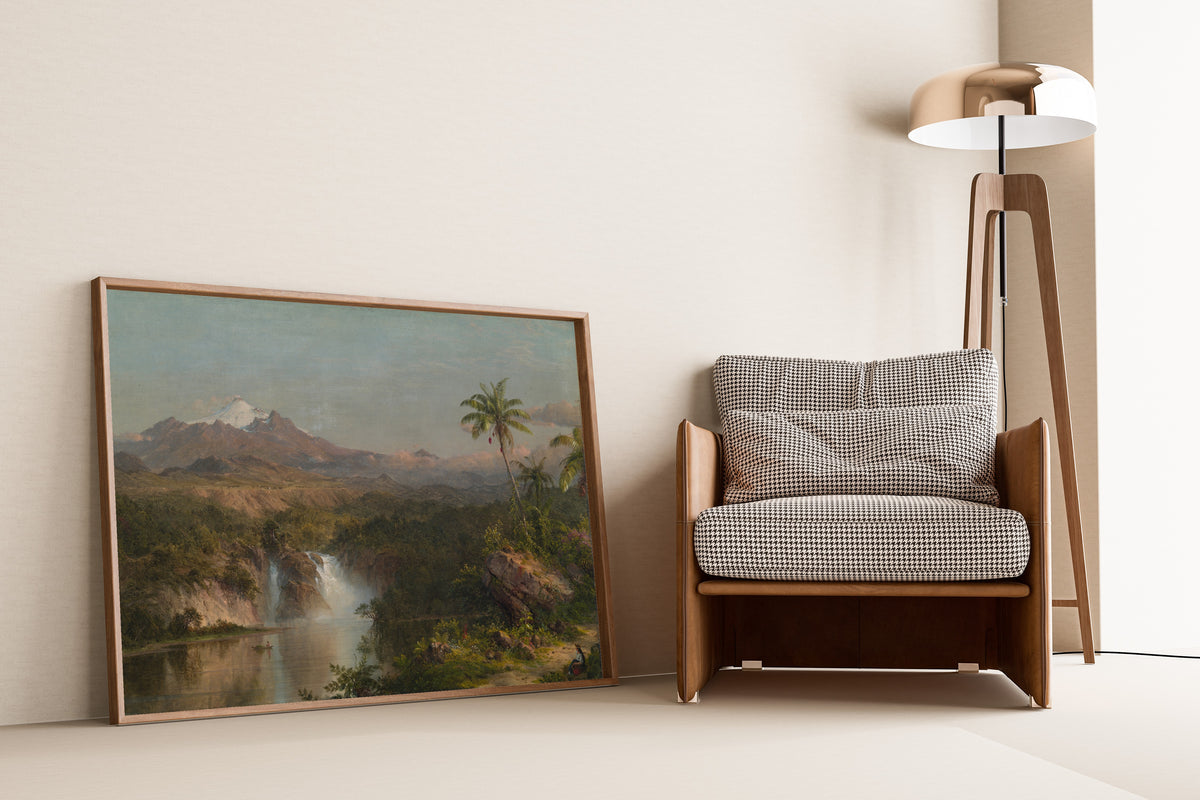 View of Cotopaxi by Frederic Edwin Church — framed and leaning against a wall beside an armchair and a floor lamp