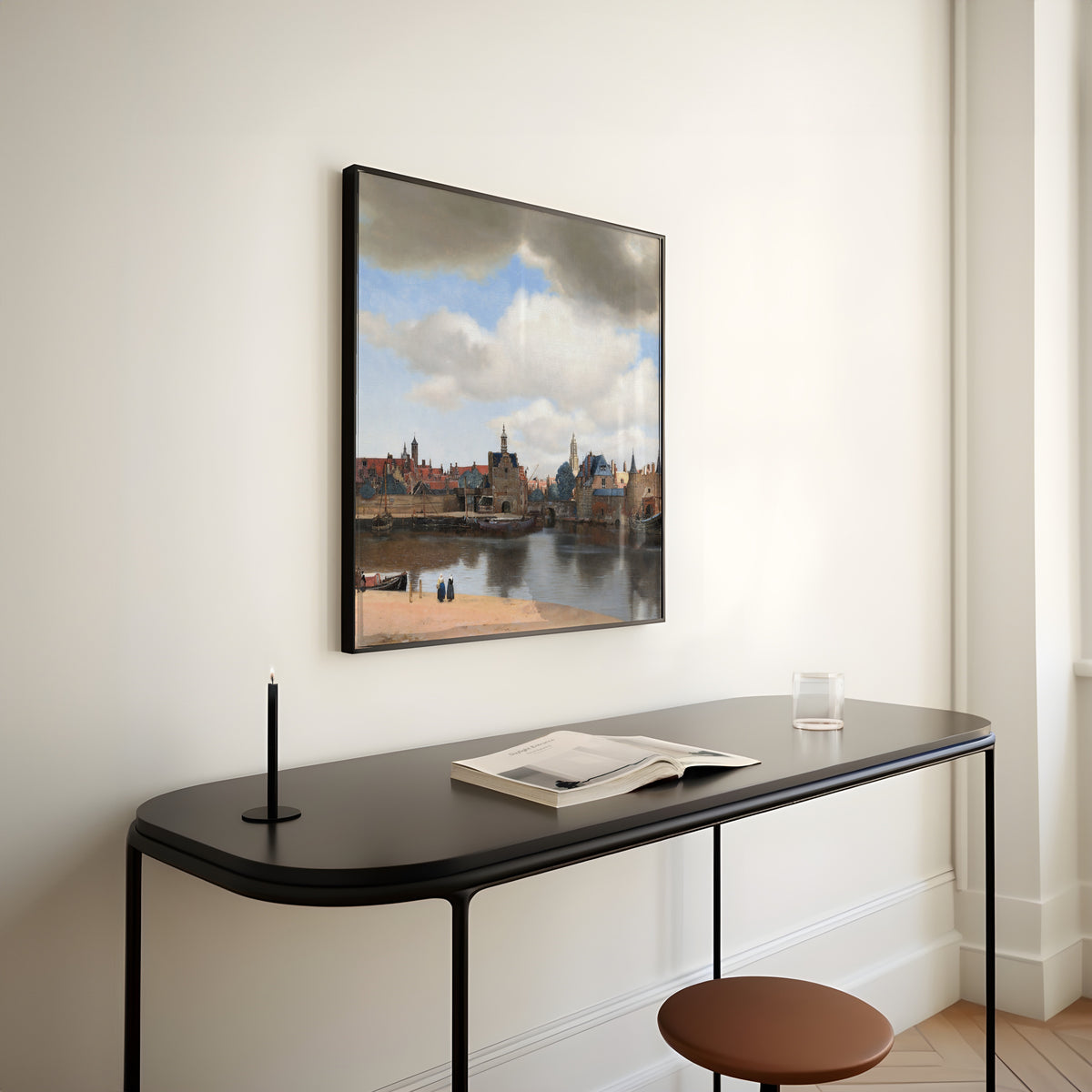 Framed art print of View of Delft by Johannes Vermeer, above a slim black console table