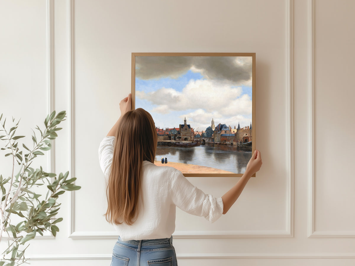 Framed art print of View of Delft by Johannes Vermeer, hung on a panelled wall