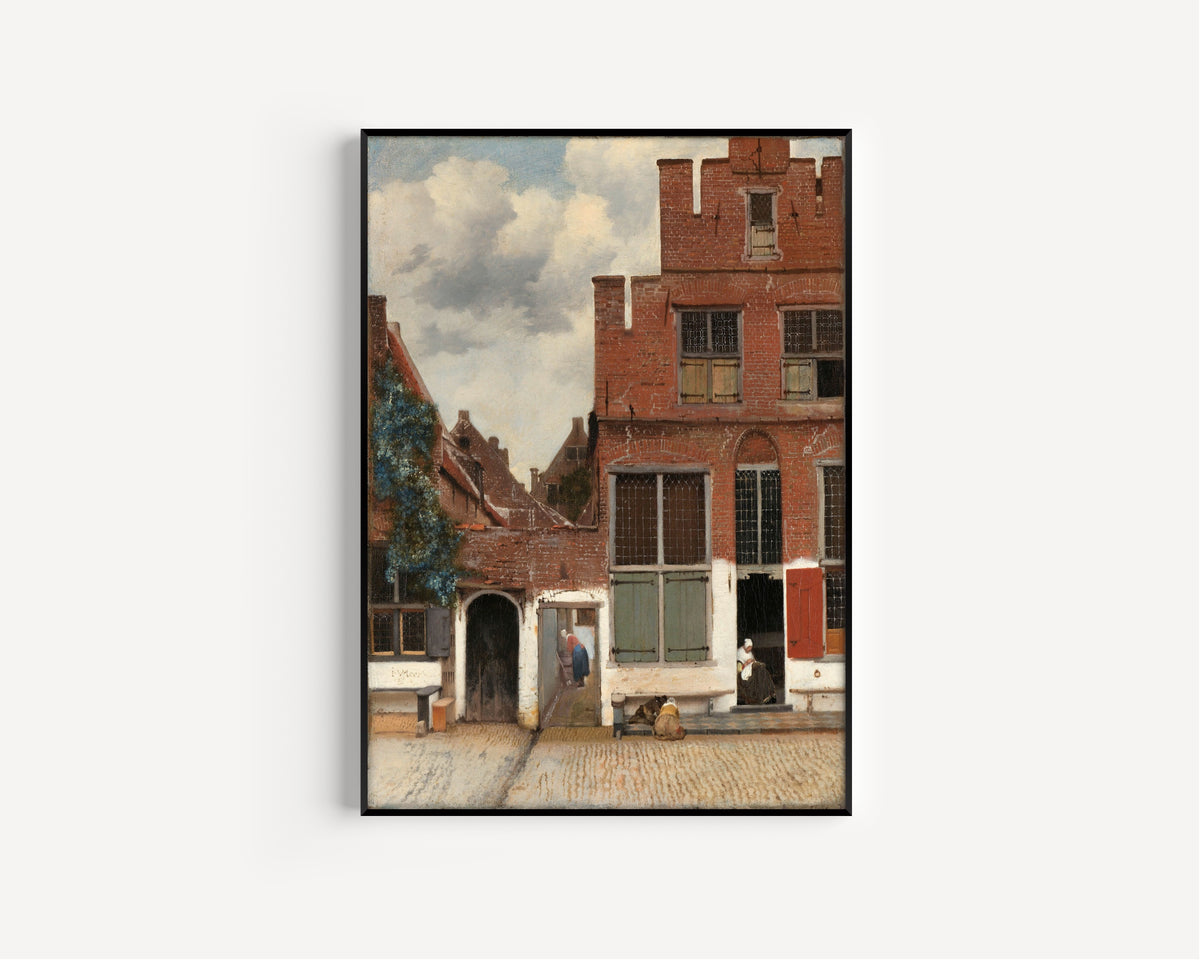 Framed art print of View of Houses in Delft, Known as ‘The Little Street’ by Johannes Vermeer, in a slim black frame on a plain white wall