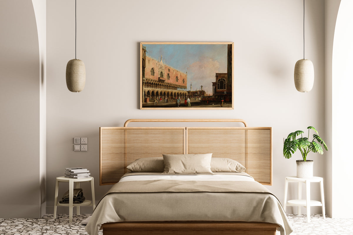 Framed art print of View of the Piazzetta San Marco Looking South by Canaletto, above a cane-headboard bed
