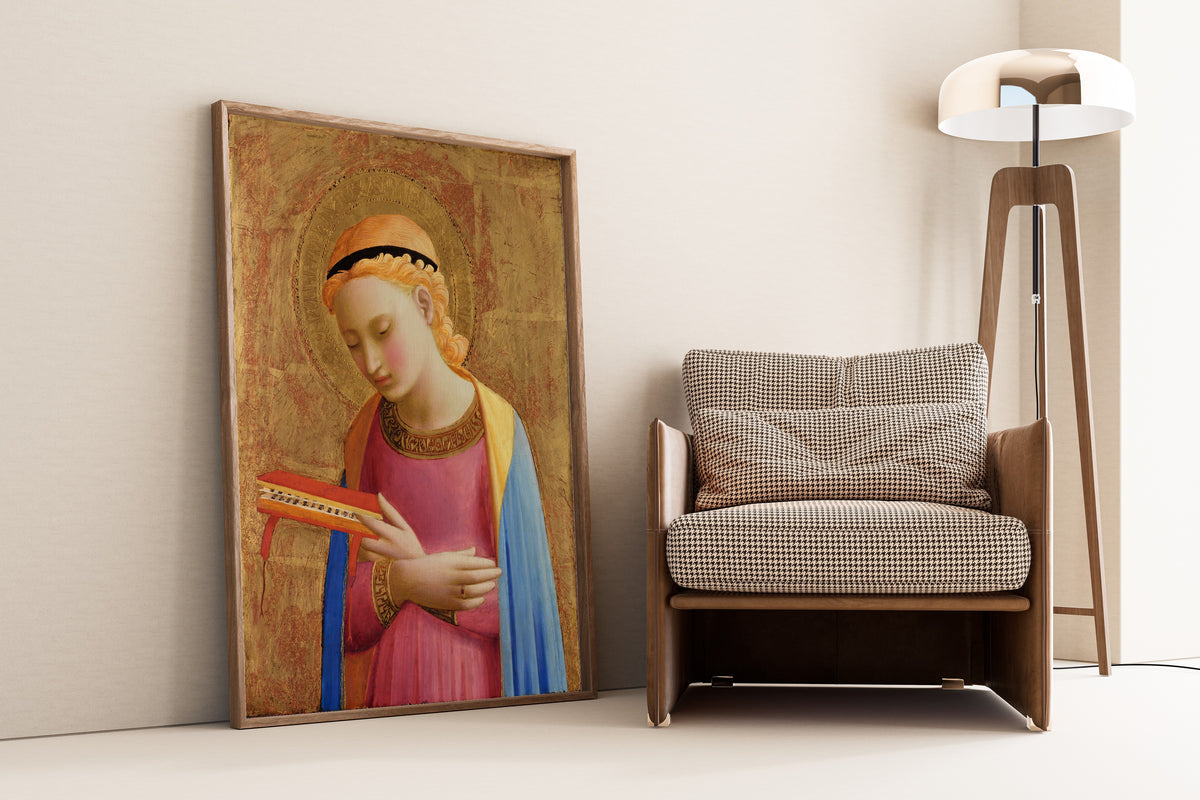 Framed art print of Virgin Annunciate by Fra Angelico, leaning against a wall beside an armchair and a floor lamp