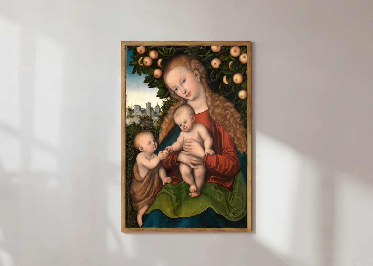 Framed art print of Virgin and Child with Saint John under an Apple Tree by Lucas Cranach the Elder, in a light wood frame on a sunlit white wall
