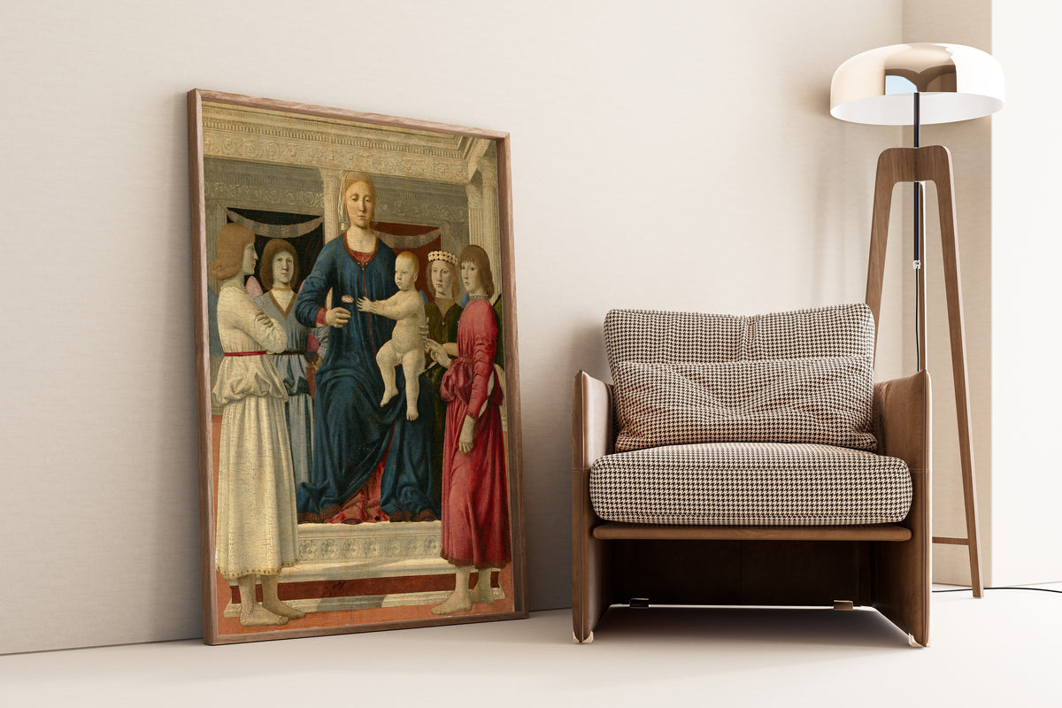 Framed art print of Virgin and child enthroned with four angels by Piero della Francesca, leaning against a wall beside an armchair and a floor lamp