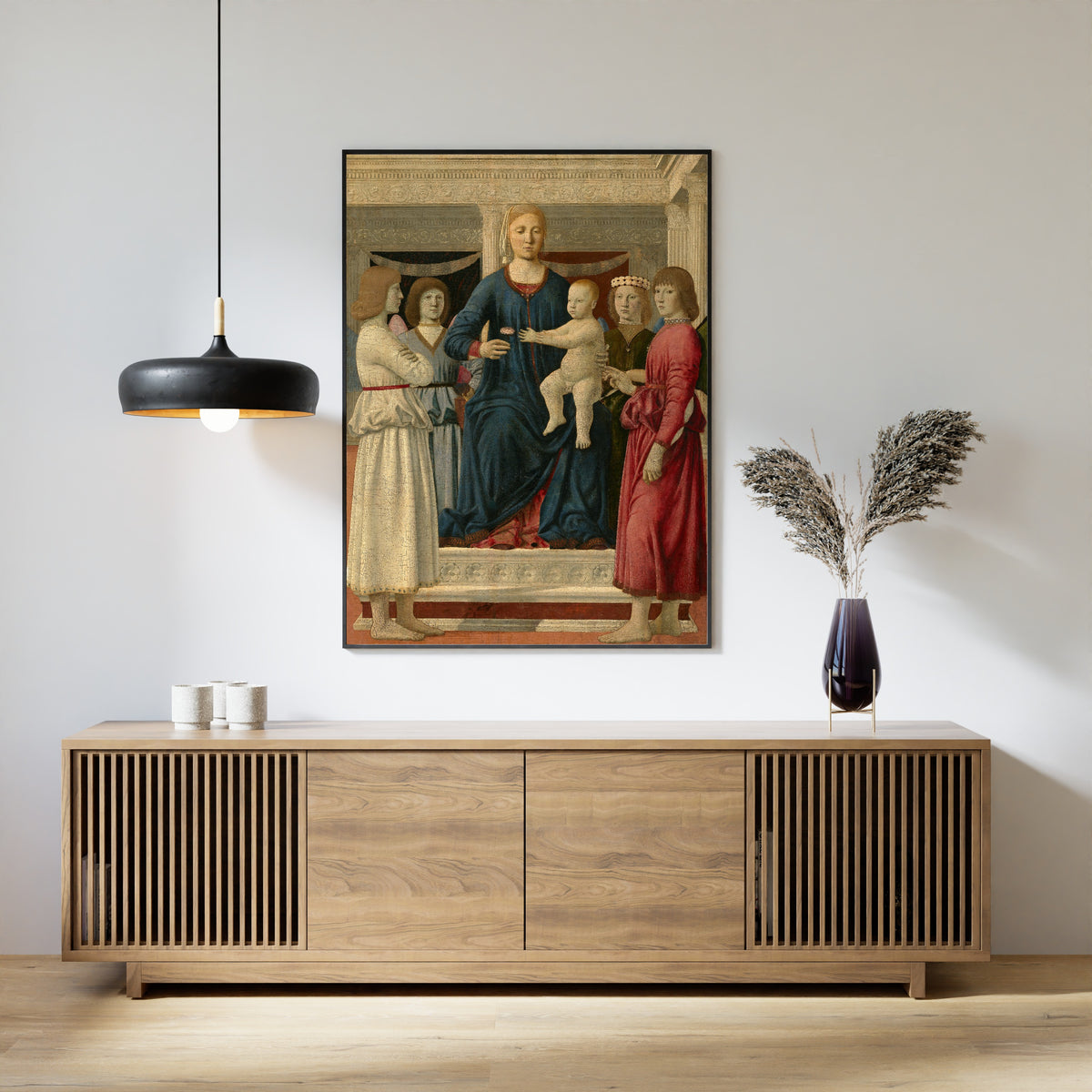 Framed art print of Virgin and child enthroned with four angels by Piero della Francesca, above a slatted wood sideboard