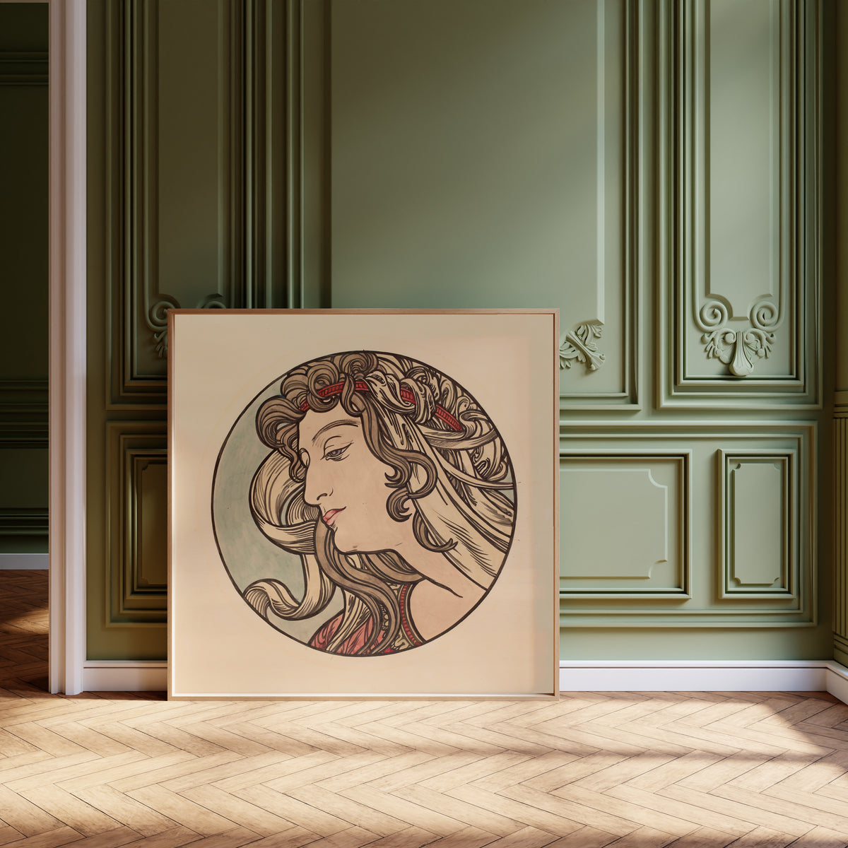 Framed art print of Vitrail pour la façade de la boutique Fouquet (red headband) by Alphonse Mucha, leaning against olive-green panelling on a herringbone floor