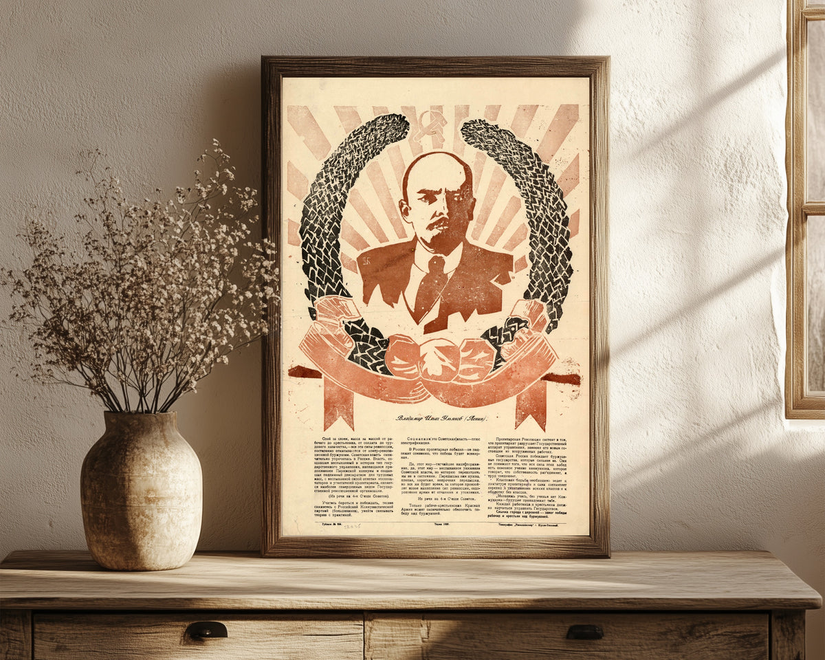 Framed art print of Vladimir Ilyich Ulyanov (Lenin), in a dark wood frame leaning on a rustic console beside dried flowers