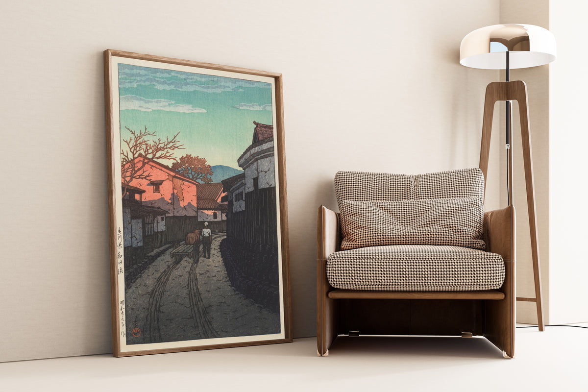 Framed art print of Wadahama in Kagawa Prefecture by Kawase Hasui, leaning against a wall beside an armchair and a floor lamp
