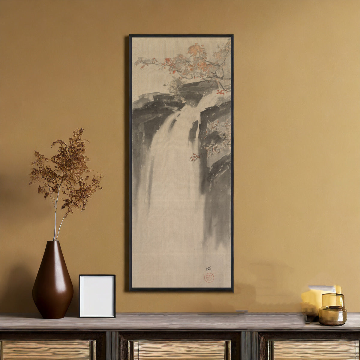Framed art print of Waterfall by Hiroshi Yoshida, on an ochre wall above a console table