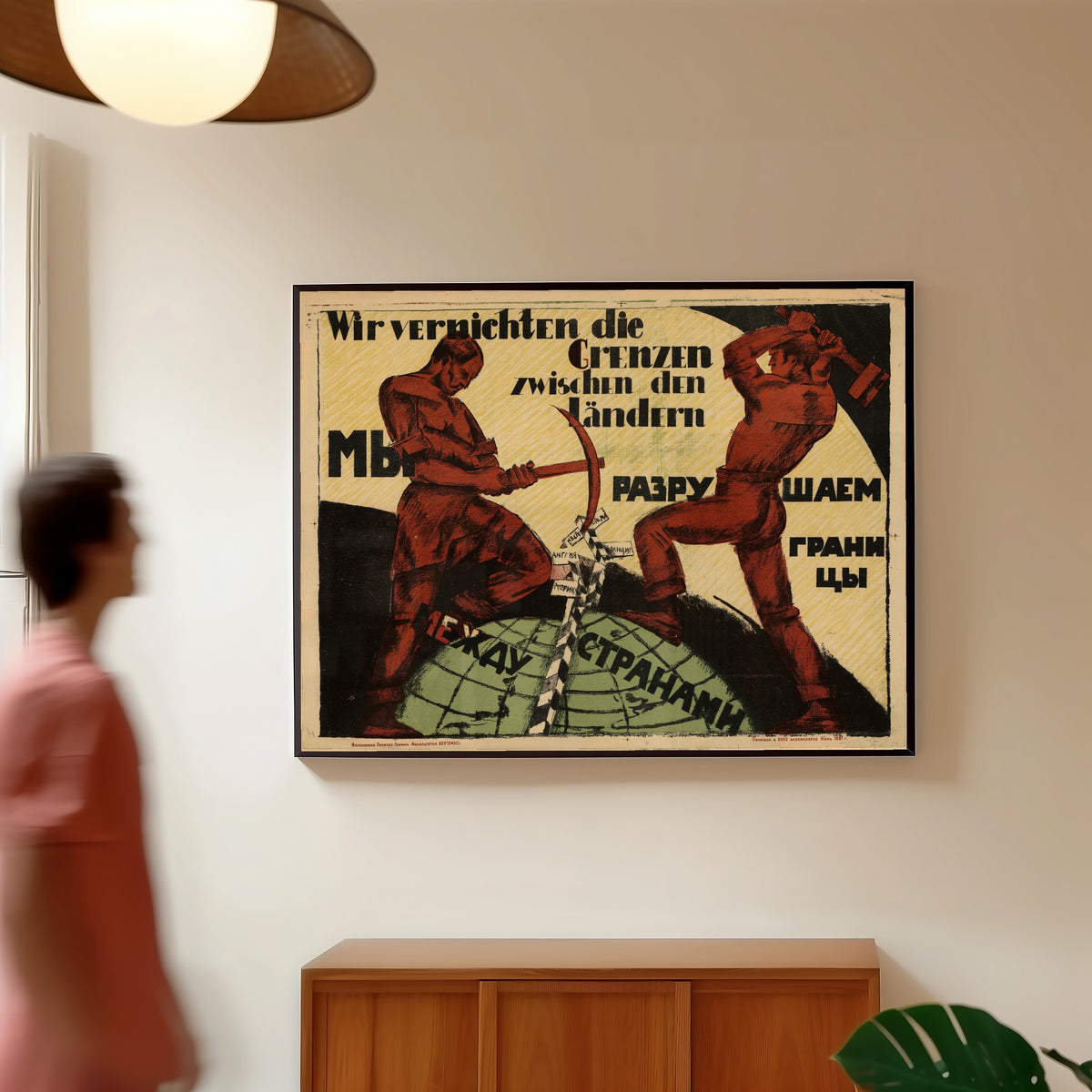 Framed art print of We are destroying the borders between countries, in a slim black frame on a warm wall in a sunlit room