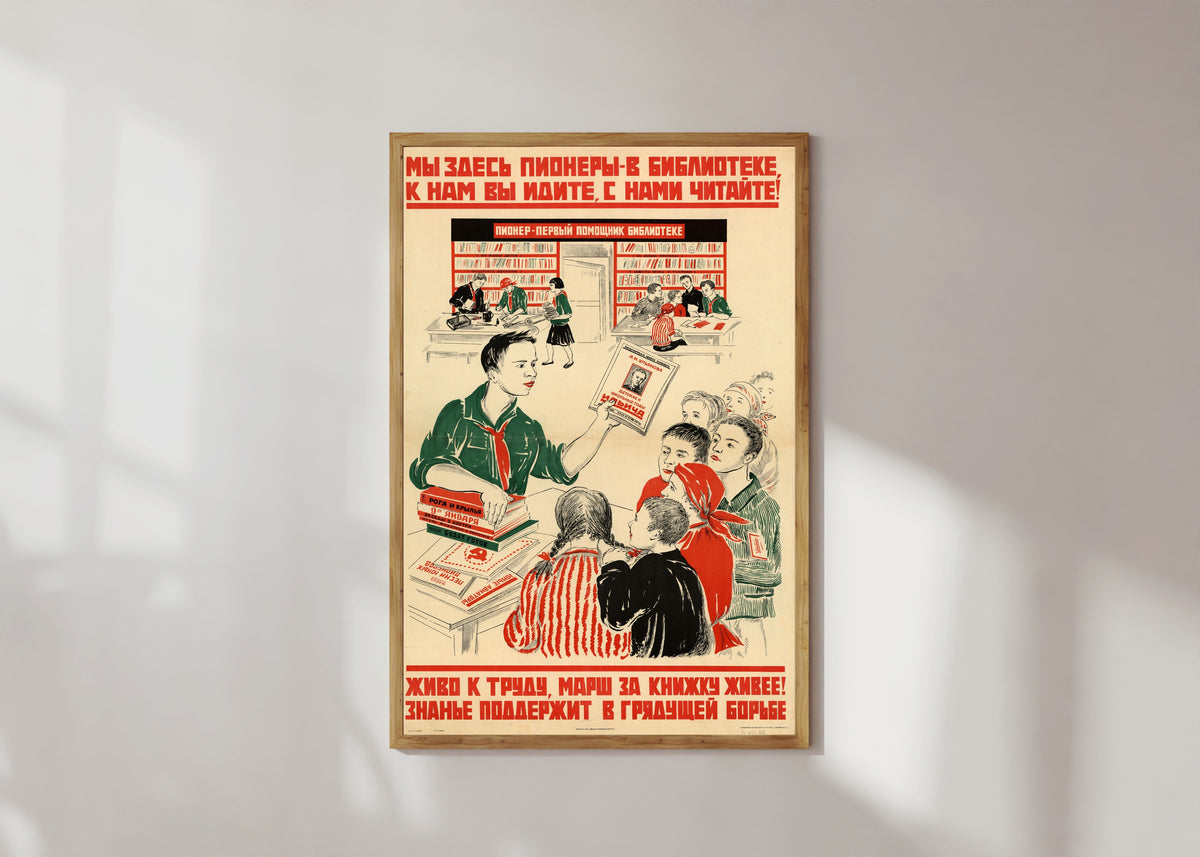 Framed art print of We pioneers are here in the library: come to us, read with us!, in a light wood frame on a sunlit white wall
