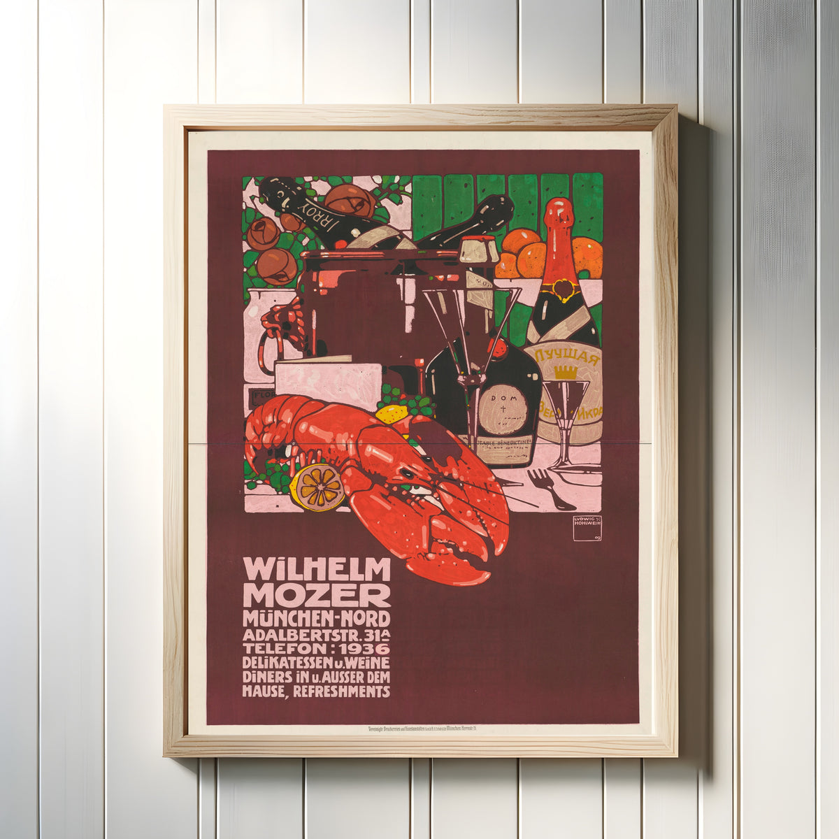 Framed art print of Wilhelm Mozer, München: Delikatessen und Weine by Ludwig Hohlwein, in a light wood frame on a white panelled wall