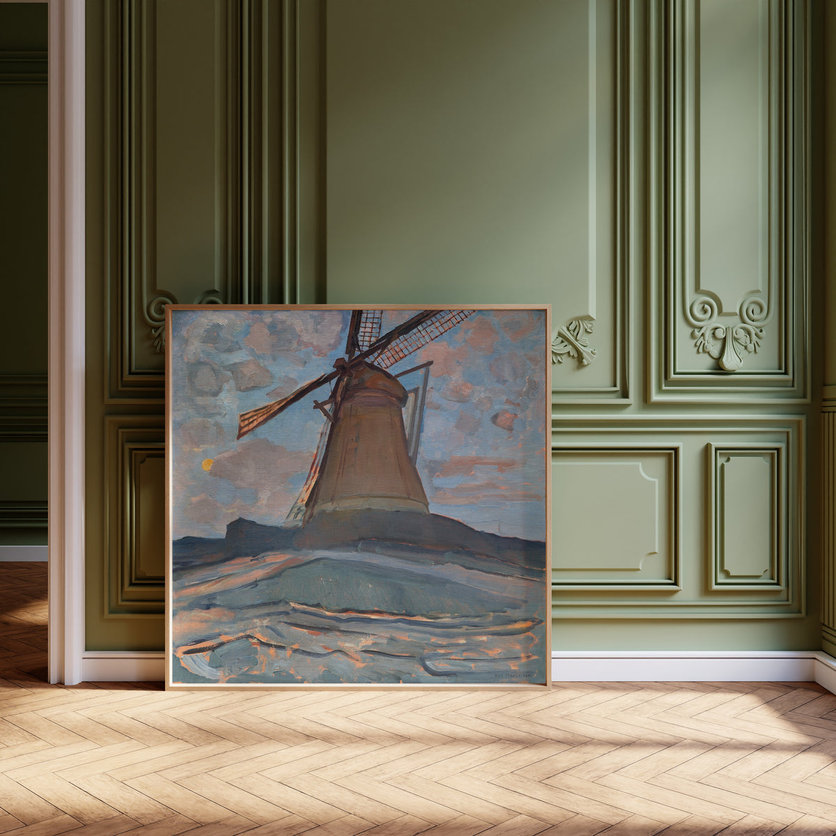 Framed art print of Windmill by Piet Mondrian, leaning against olive-green panelling on a herringbone floor
