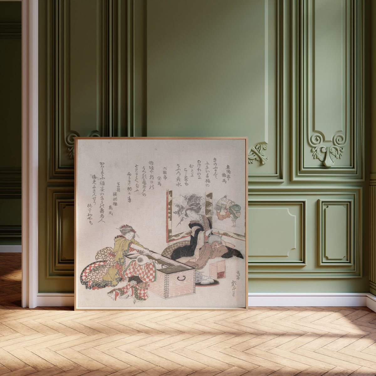 Framed art print of Women Preparing Tea Around the Fire-Holder by Katsushika Hokusai, leaning against olive-green panelling on a herringbone floor