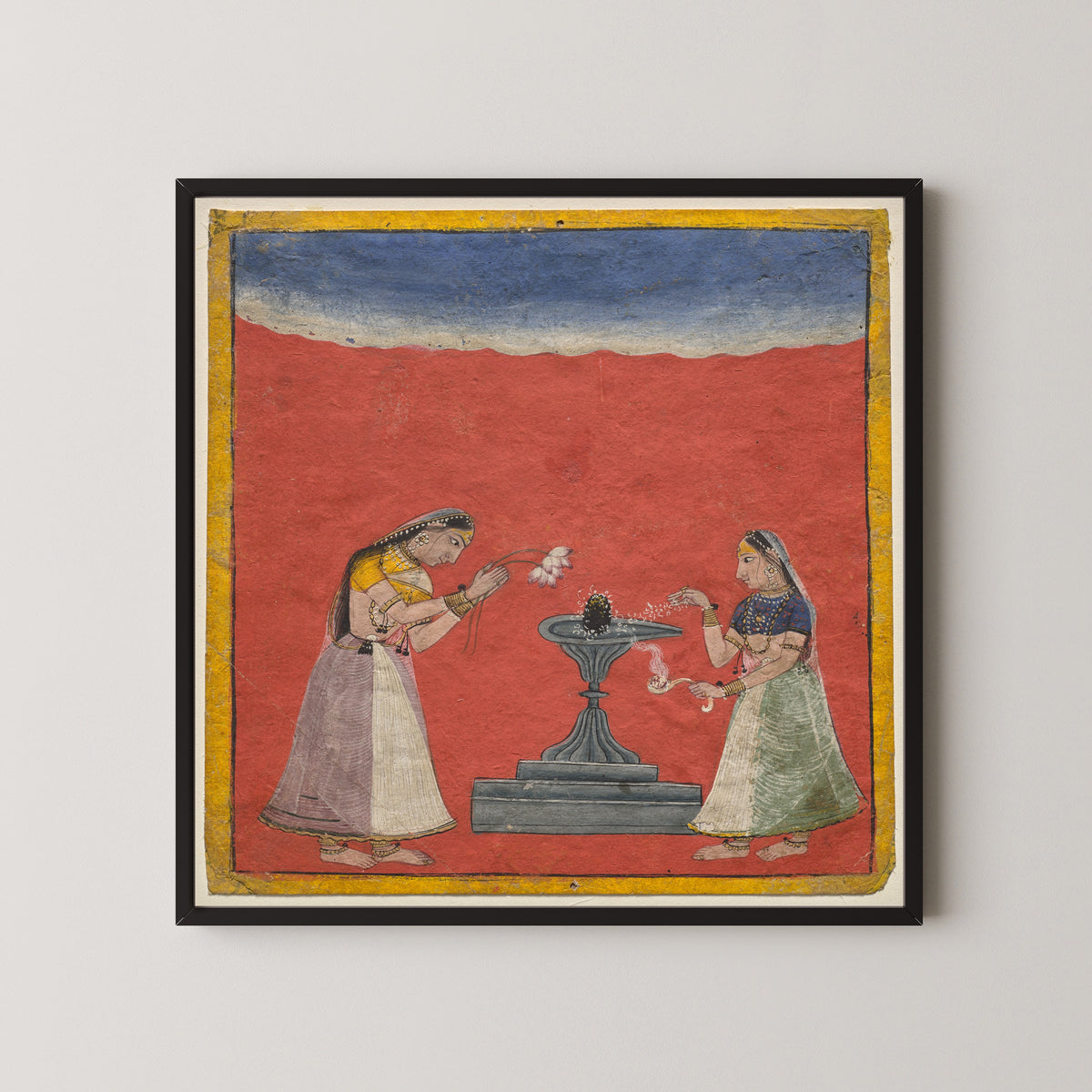 Framed art print of Women worshiping a Shiva linga: Devagandhari Ragini of Hindol Raga by Pahari school, in a black frame on a pale wall