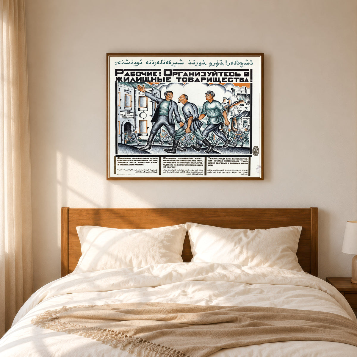 Framed art print of Workers! Organise into housing cooperatives!, in a slim wood frame above a bed in a sunlit bedroom