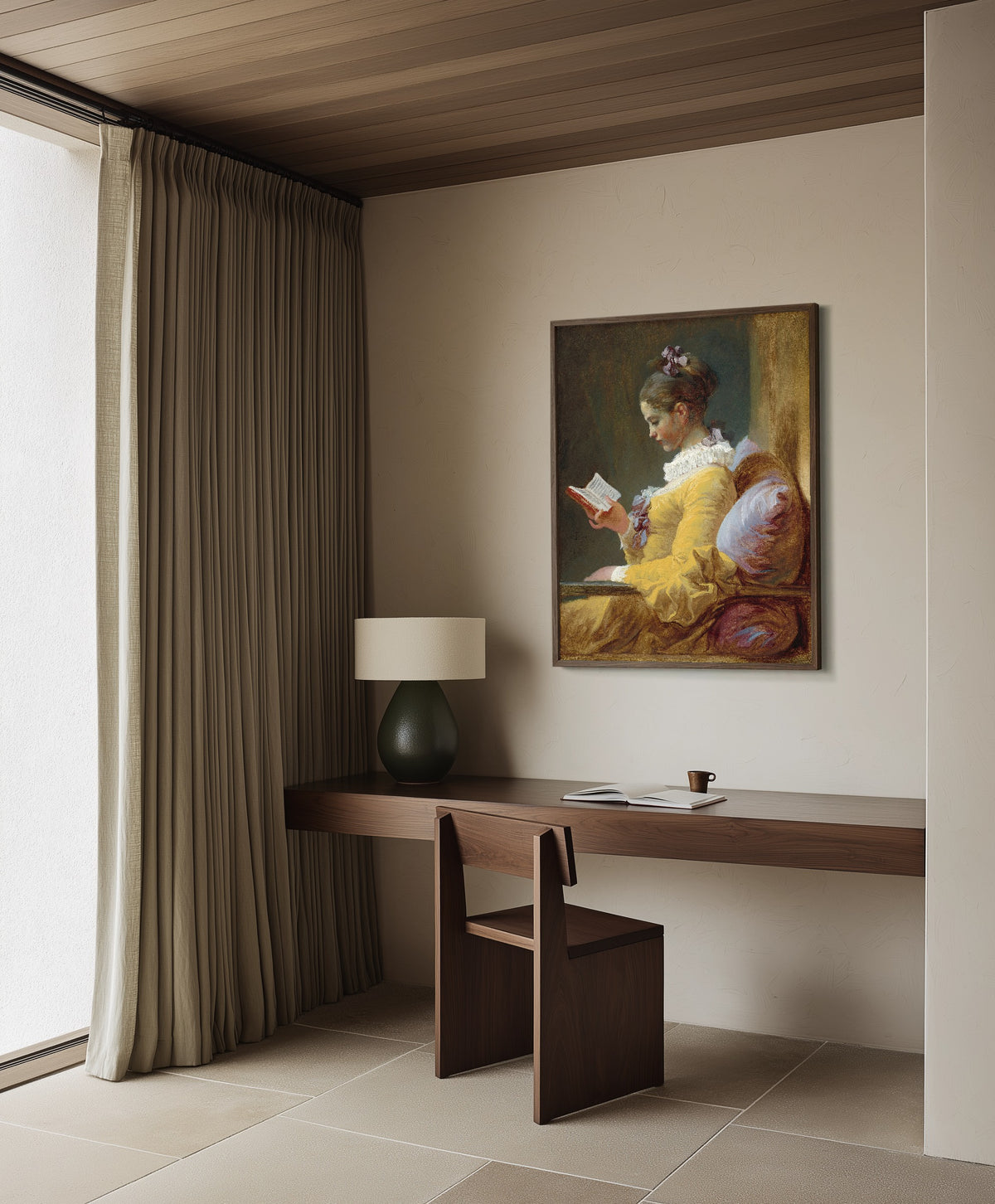 Framed art print of Young Girl Reading by Jean-Honoré Fragonard, in a dark wood frame on a plaster wall above a walnut desk