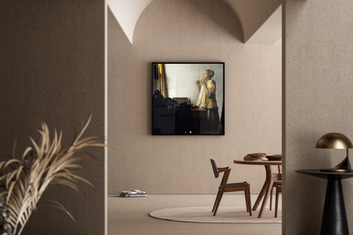 Framed art print of Young Woman with a Pearl Necklace by Johannes Vermeer, in a sunlit dining corner
