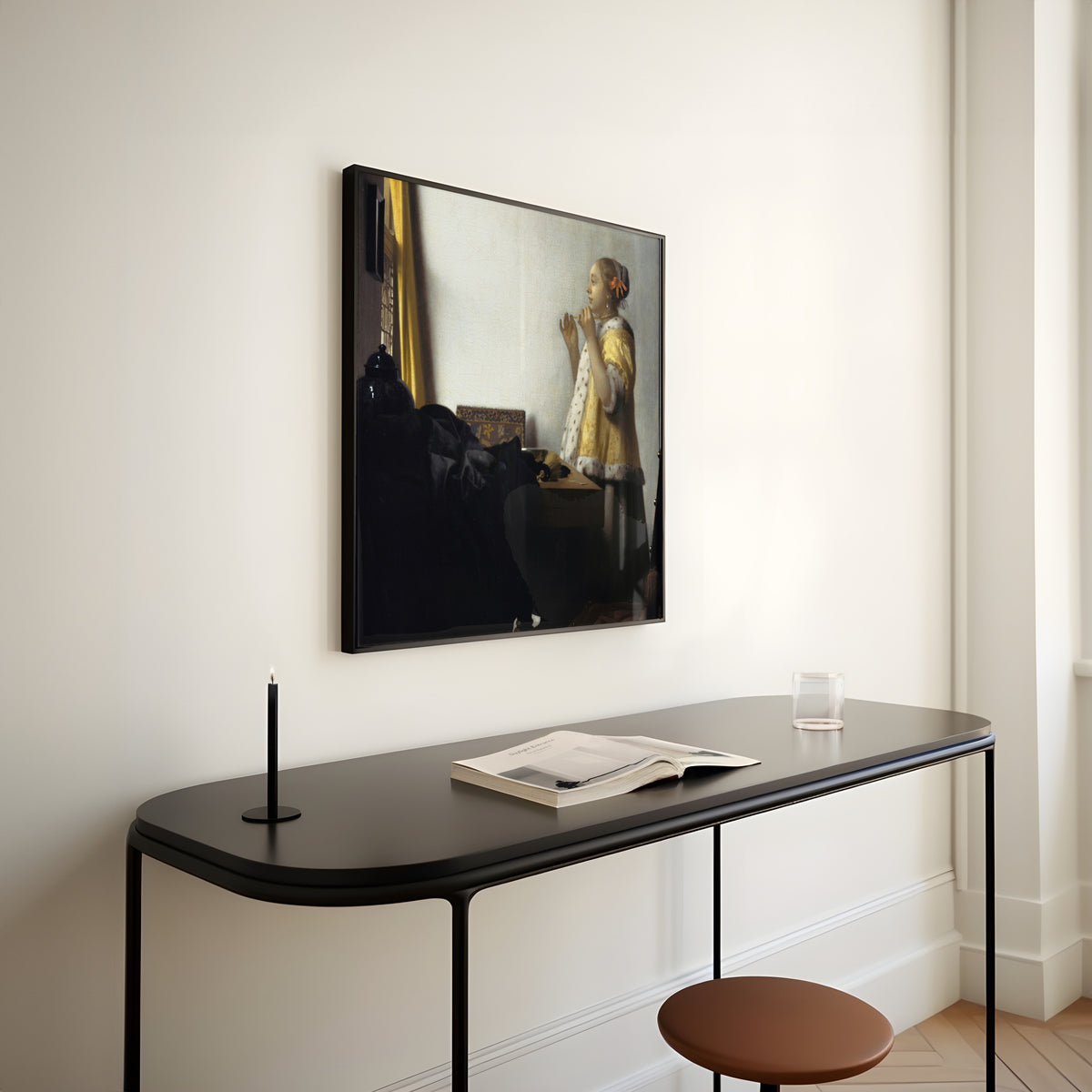 Framed art print of Young Woman with a Pearl Necklace by Johannes Vermeer, above a slim black console table