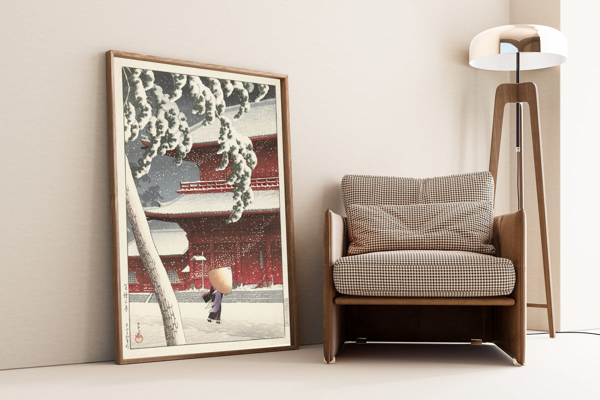 Framed art print of Zojoji Temple, Shiba by Kawase Hasui, leaning against a wall beside an armchair and a floor lamp