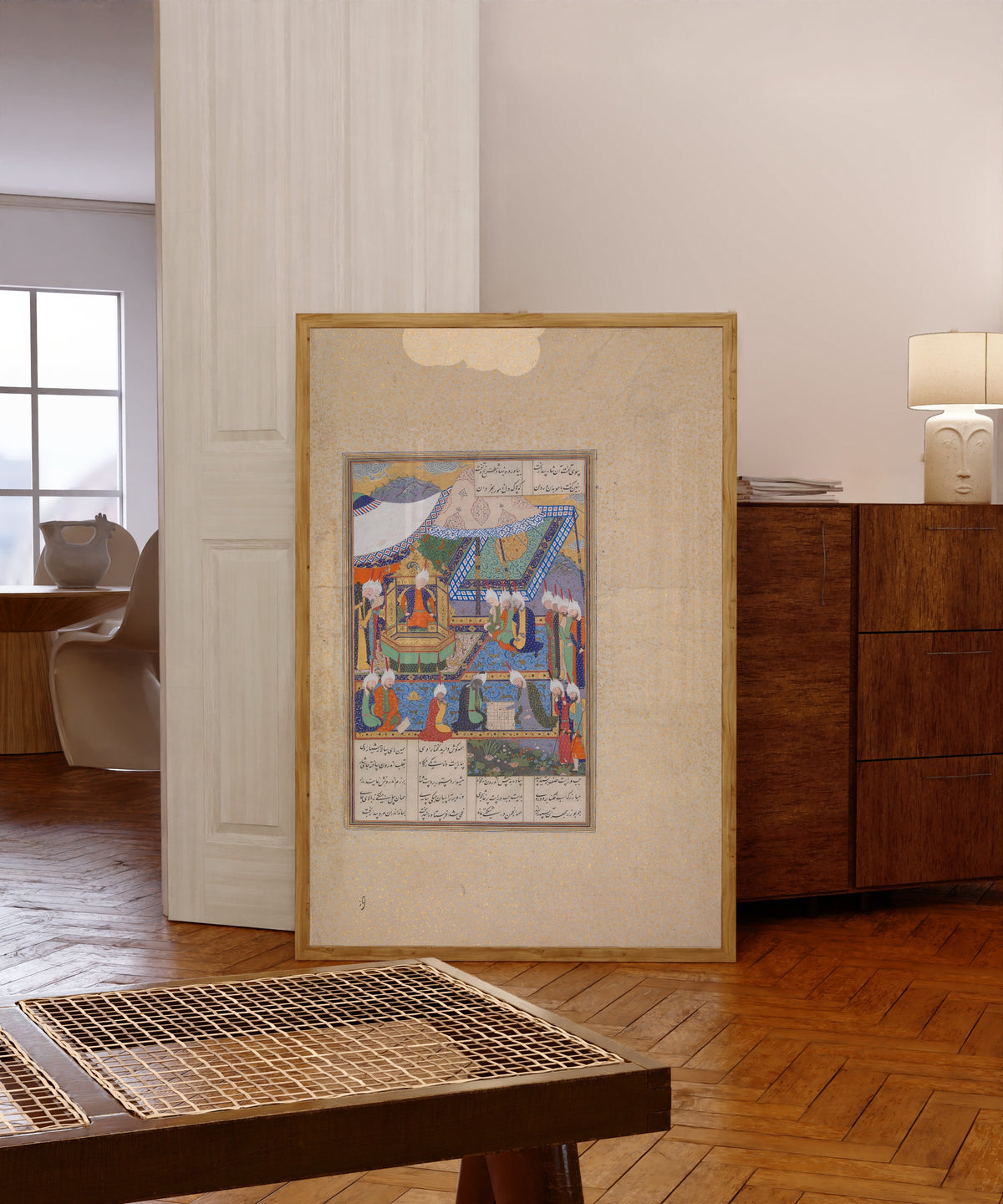 Framed art print of Shahnama of Shah Tahmasp: Buzurjmihr… by Abd al-Vahhab (attributed), in a light wood frame leaning in a warm room with a parquet floor
