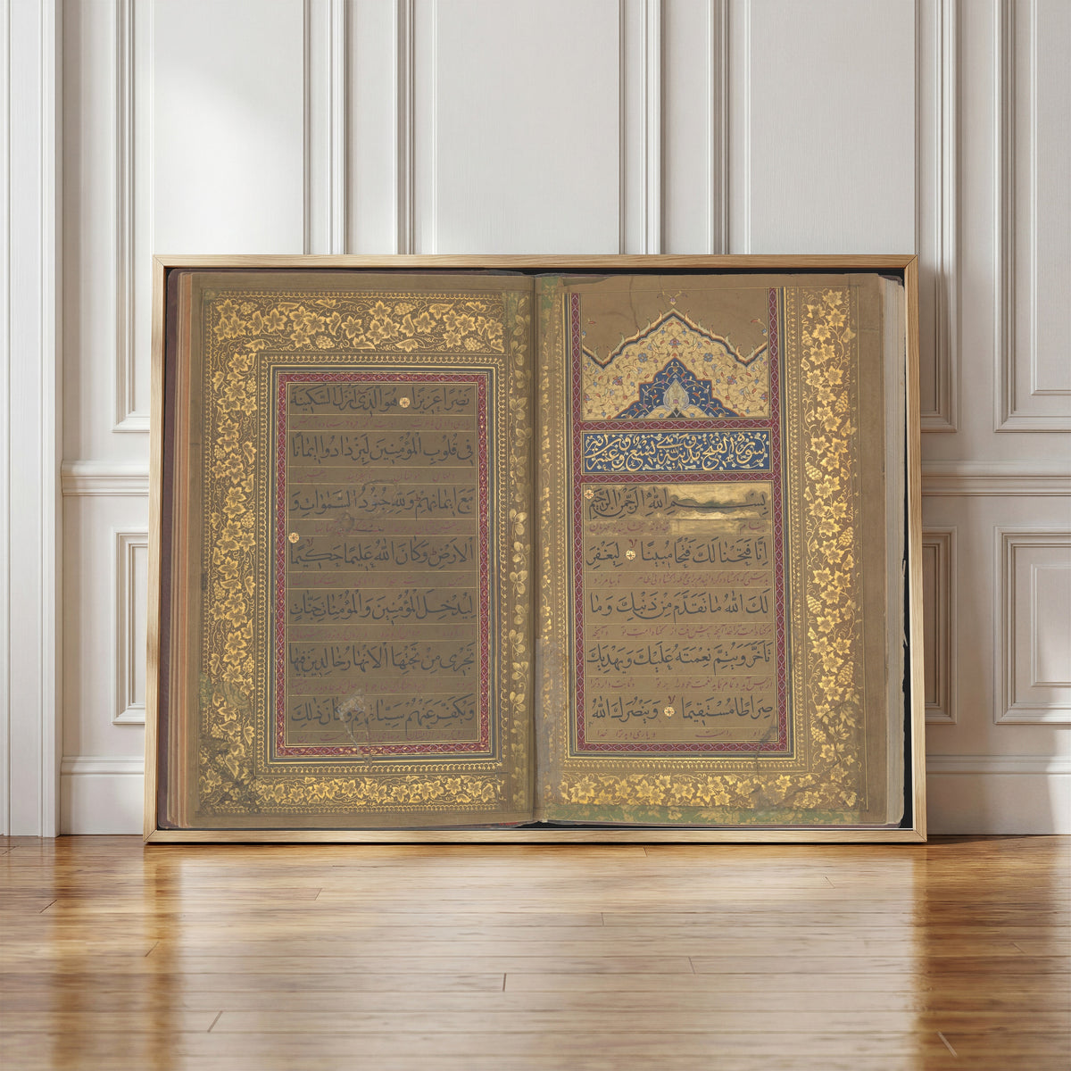 Framed art print of Book of Prayers: Opening of Surat al-Fath by Ahmad Nairizi, in a light wood frame leaning against a panelled white wall