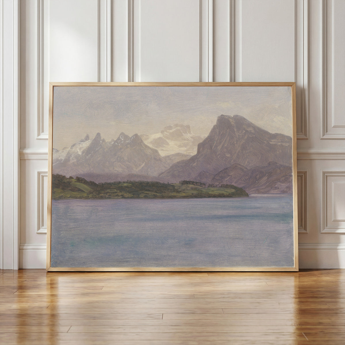 Framed art print of Alaskan Coast Range by Albert Bierstadt, in a light wood frame leaning against a panelled white wall