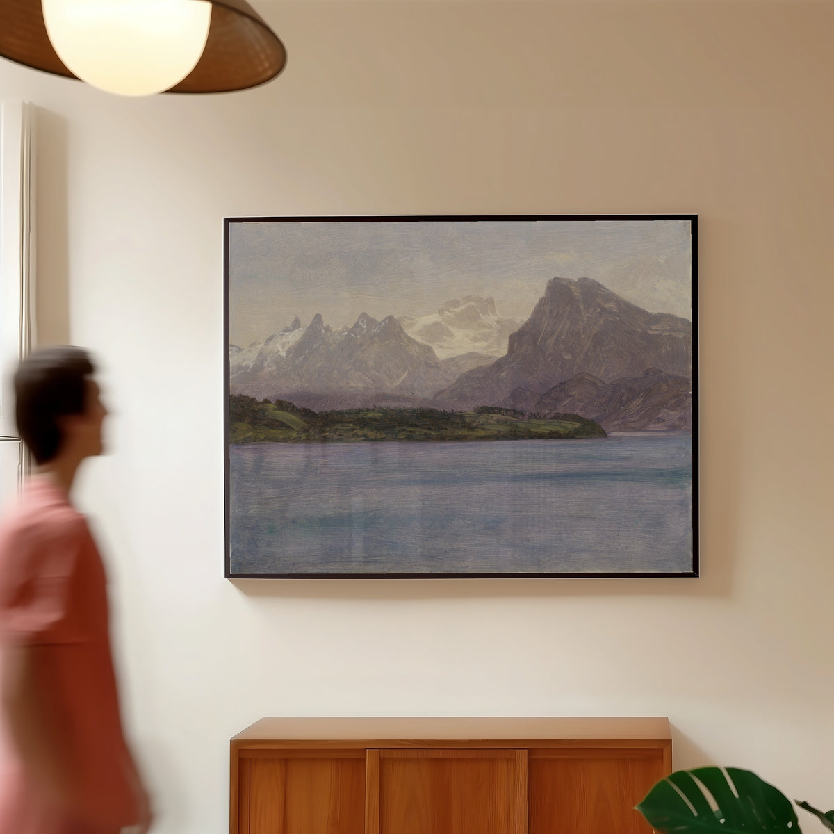 Framed art print of Alaskan Coast Range by Albert Bierstadt, in a slim black frame on a warm wall in a sunlit room