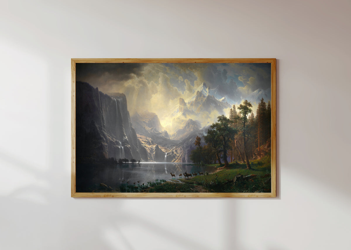 Framed art print of Among the Sierra Nevada, California by Albert Bierstadt, in a light wood frame on a sunlit white wall