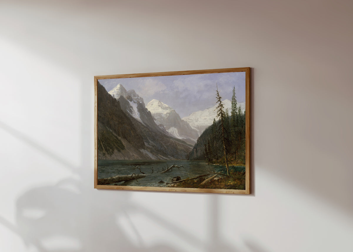 Framed art print of Canadian Rockies (Lake Louise) by Albert Bierstadt, in a light wood frame on a sunlit white wall, seen at a slight angle